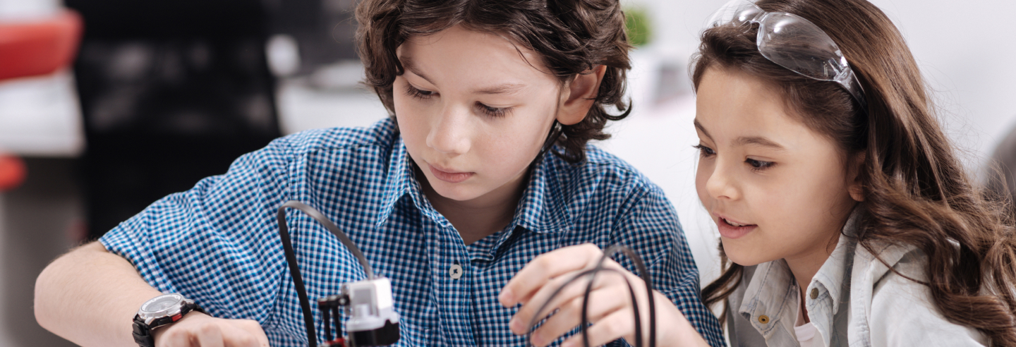 Girl and boy looking at something on a table