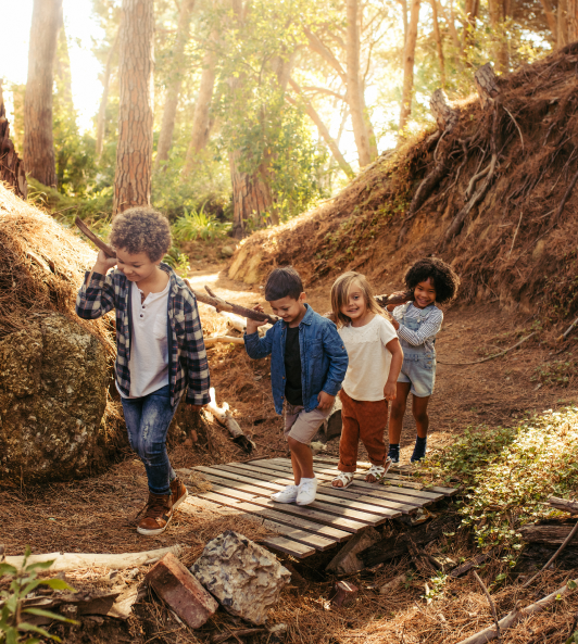Four kids carrying a wood stick