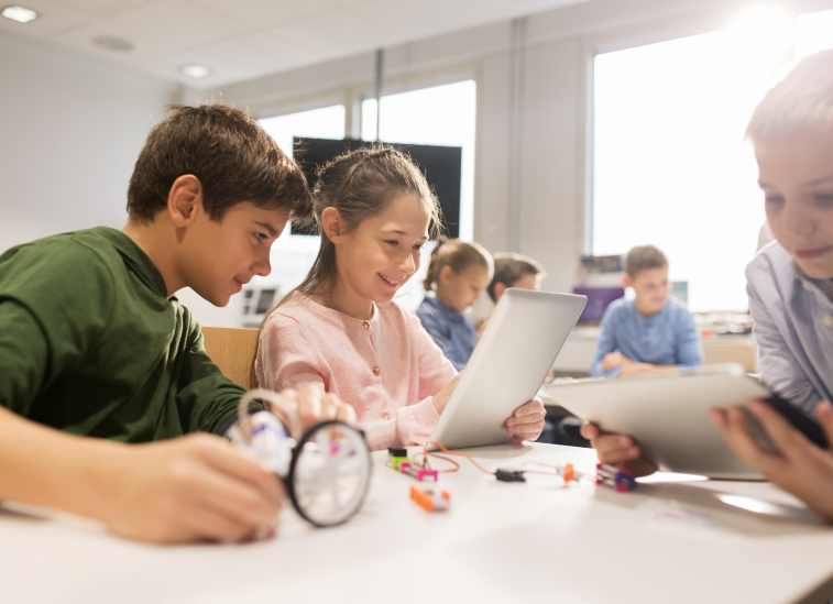 Kids smiling while using a tablet
